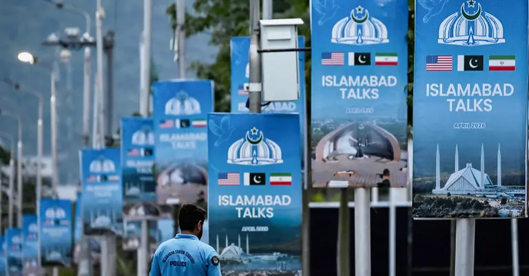 ইরান-যুক্তরাষ্ট্র শান্তি আলোচনায় পাকিস্তানের মধ্যস্থতা পোস্টারের পাশ দিয়ে যাচ্ছেন এক পুলিশ সদস্য